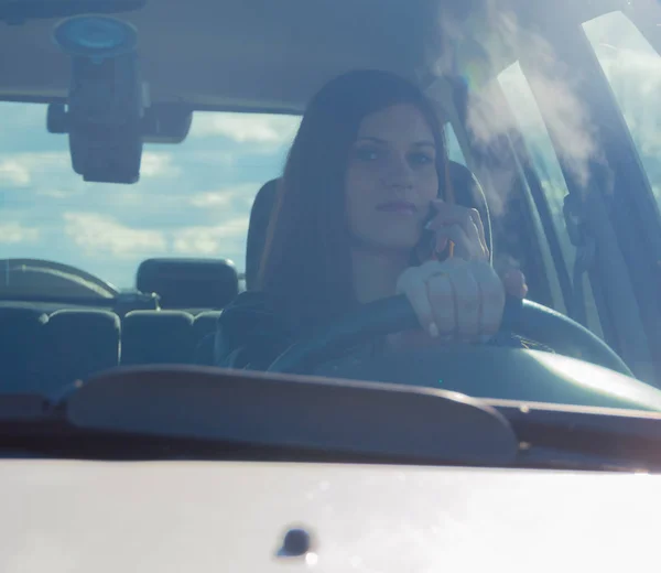Hermosa chica hablando por teléfono mientras conduce . — Foto de Stock