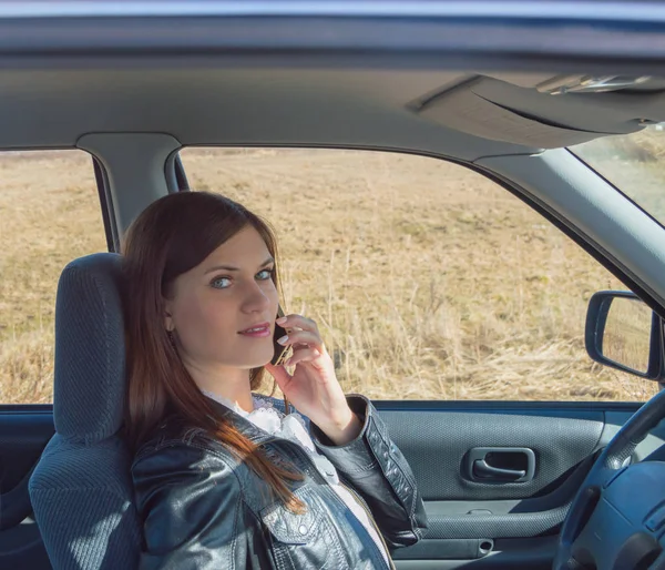 Conducir un coche una chica atractiva hablando por teléfono . — Foto de Stock