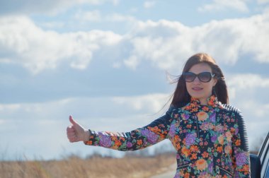 başparmak güzel bir kız yetiştirme arabayı durdurur.