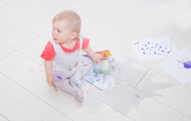 bir çocuk tarafından boya kaplı su oturur bir su birikintisi içinde.