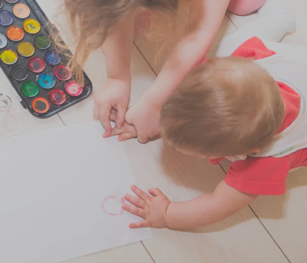 Grande bambino insegna piccolo per disegnare le mani . — Foto Stock