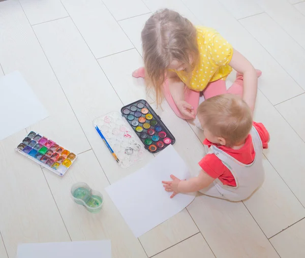 Grande seduta sul pavimento due bambini dipingere . — Foto Stock