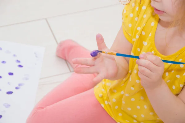 Çocuk boya ile elle bir fırça ile çizer. — Stok fotoğraf