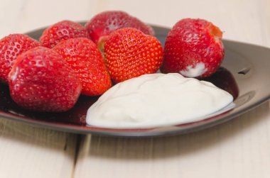 Çilekli dondurma karanlık bir plaka üzerinde yakın çekim.