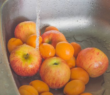 Lavaboda yıkama için şeftali ve elma.