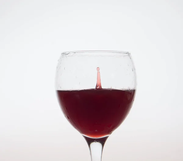 Kapkou červeného vína ve skle. — Stock fotografie