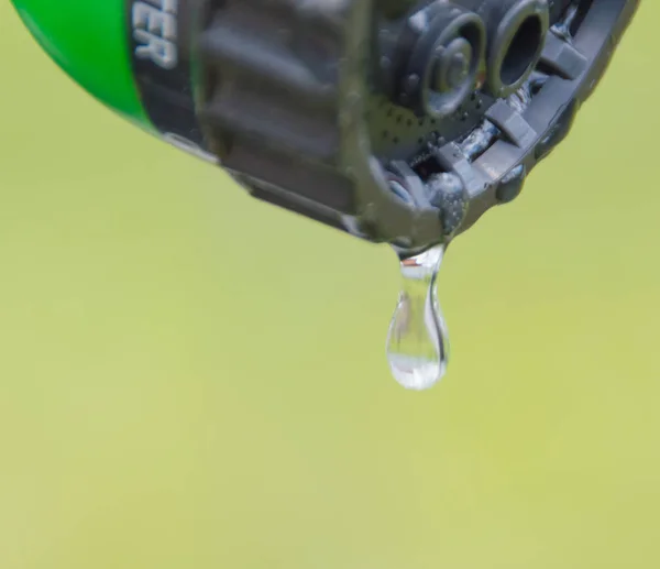 Con riego puede gotas de una gota de agua, primer plano . — Foto de Stock