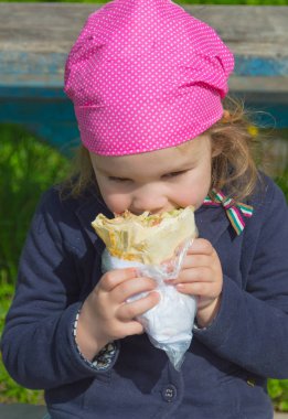 yakın çekim, açık güneşli bir havada bir bebek yiyor.