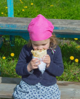 Çocuk street yürüyüş üzerinde bir Shawarma yiyor.