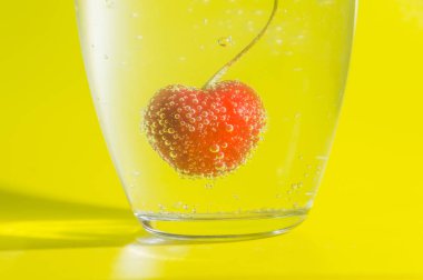 Sarı bir arka plan cam kabarcıkları ile kiraz.