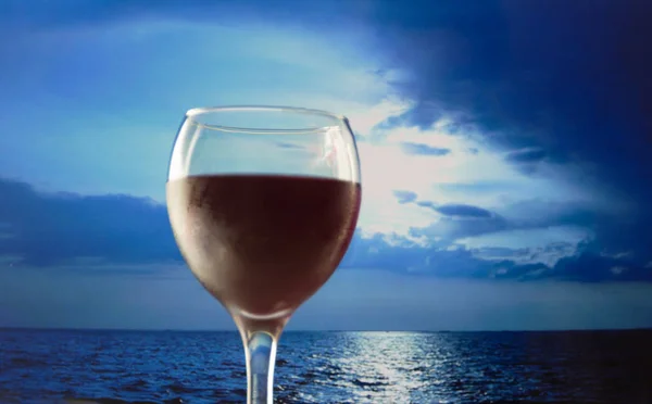 Na obloze za skleničku červeného vína. — Stock fotografie
