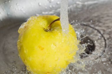 Apple lavaboda su akışı altında sarı.