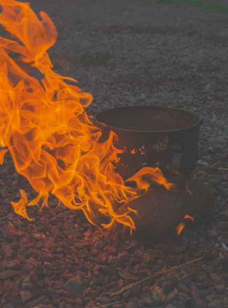 Parlak bir alev ile yanmak taşlar ve kamp pot. — Stok fotoğraf