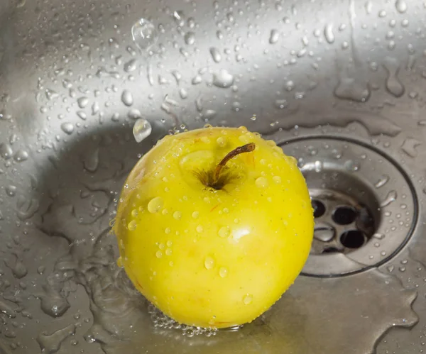 Nel lavandino presso le gocce d'acqua giallo mela . — Foto Stock
