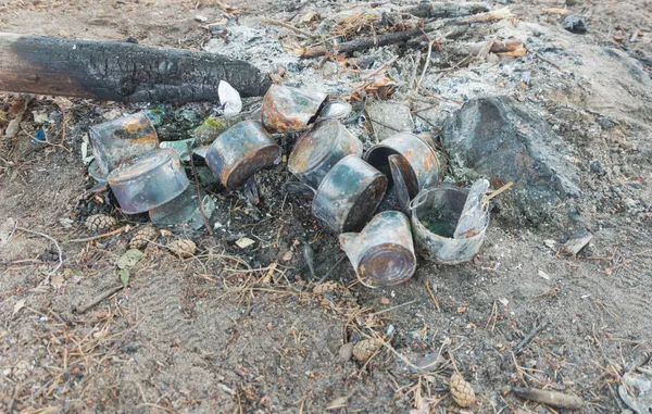 Las latas quemadas cerca de un incendio . — Foto de Stock