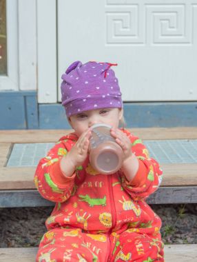 şişeden bebek şapkalı yiyor.