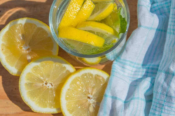  bir ahşap masa köpüklü su üzerinde limon ve nane, görünümü