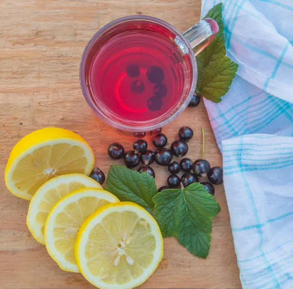 Auf dem Tisch Sommergetränk mit Zitrone und Beeren, schwarzen Johannisbeeren — Stockfoto