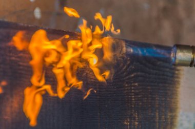 Gaz yakıcı ateşi işlenir kömürleşmiş odun.