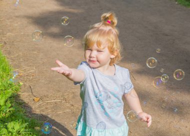 Çocuk parkta sabun köpüğü takip.