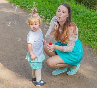 Anne ve çocuk sabun köpüğü yürüyüşe izin.