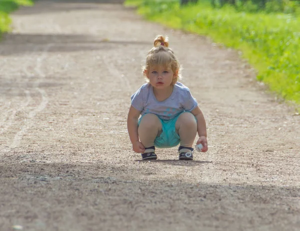 Sur la promenade, l'enfant s'assied sur la route . — Photo