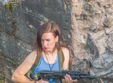 Beton duvar, silah ile kız.