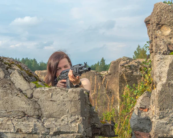 За бетонною стіною дівчина з пістолетом приймає ціль, крупним планом . — стокове фото