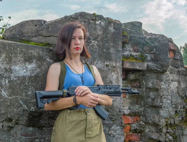Крупним планом, бетонна стіна позує дівчину з пістолетом . — стокове фото