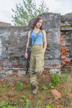 Beton duvar kız silahla poz.