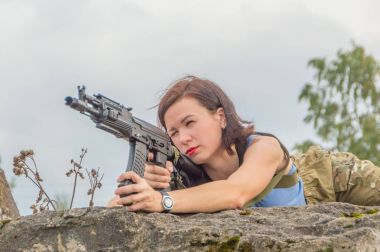 Kız bir silahtan amaçlayan aşağı yalan.