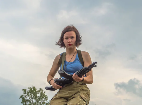 Fille avec un pistolet contre le ciel . — Photo