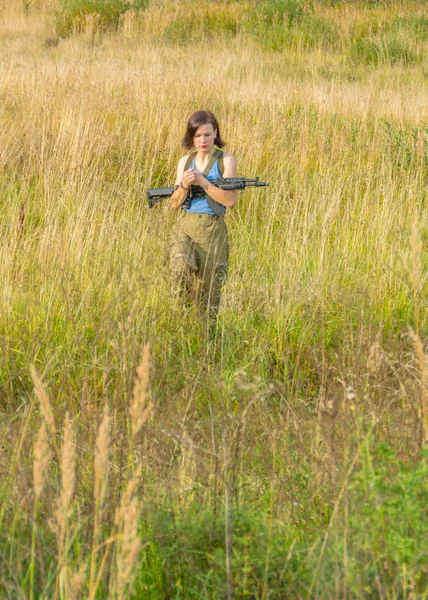 A rapariga com uma arma está em campo. . — Fotografia de Stock