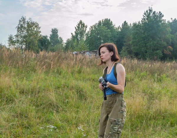 Flicka med en pistol som gå på gräset. — Stockfoto