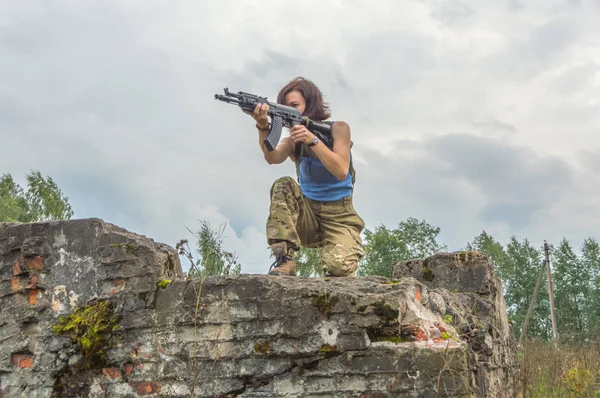 Chica con armas en una pared de ladrillo . — Foto de Stock