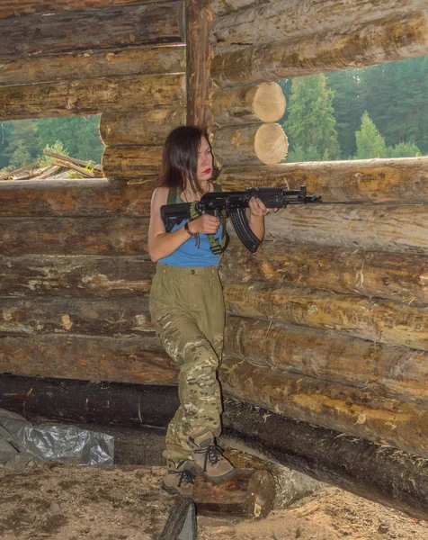 I helfigur tjej med en pistol i en trä defensiv täcka. — Stockfoto
