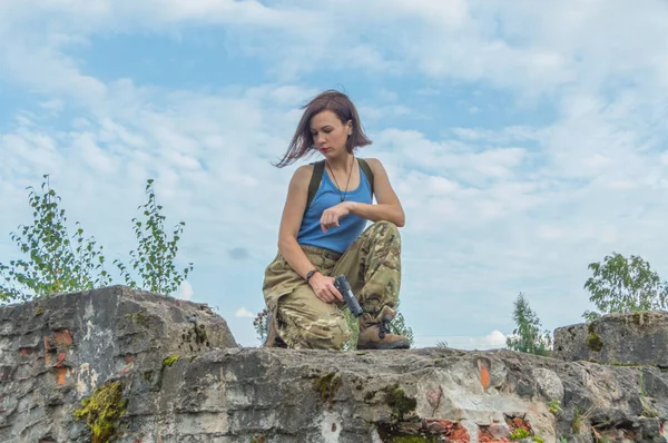 La fille avec le pistolet sur le béton le mur . — Photo