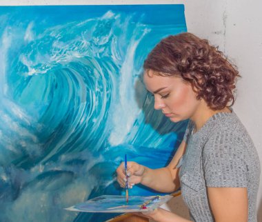 atölyede kız boyalar çizer..