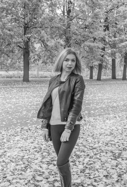 Czarno-białe, w parku jesienny dzień idzie atrakcyjną dziewczyną — Zdjęcie stockowe