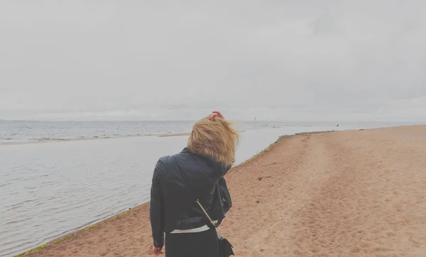 Συννεφιασμένη μέρα ένα όμορφο κορίτσι περπατά στην παραλία — Φωτογραφία Αρχείου