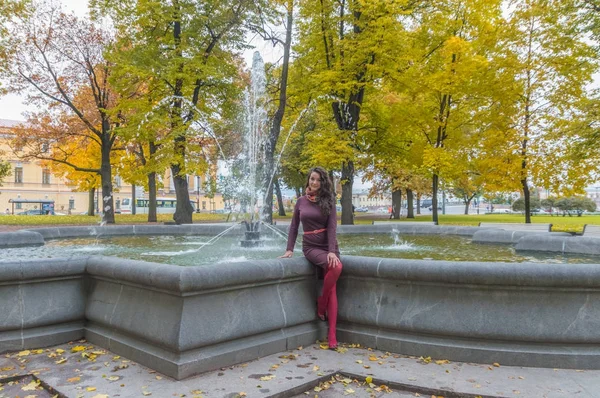 Día de otoño una chica atractiva en la fuente —  Fotos de Stock