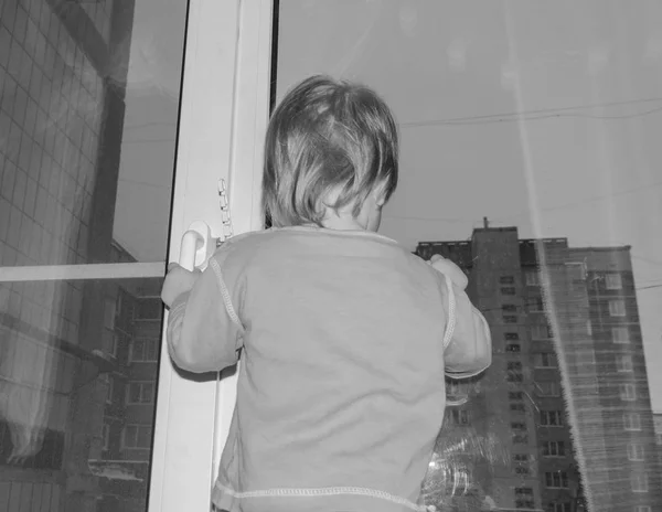 ที่หน้าต่าง เด็กคิดถึงพ่อแม่ของเธอ — ภาพถ่ายสต็อก