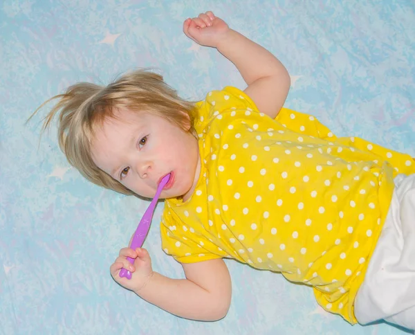 Escova de dentes da criança deitada na cama — Fotografia de Stock
