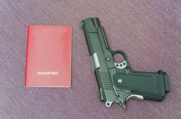 Sobre un fondo de tela, un arma con pasaporte — Foto de Stock