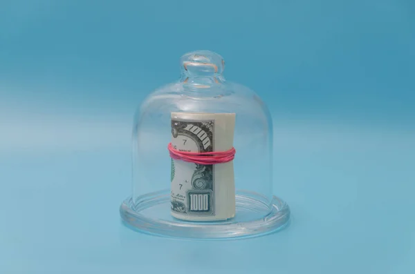 Nahaufnahme, Dollarpackung unter Glaskappe, auf blauem Hintergrund — Stockfoto