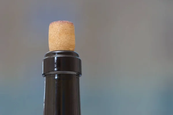 The closeup of the neck of a wine bottle closed with cork backgr — Stock Photo, Image