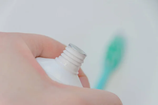 In the hands of a closed toothpaste, close-up — Stock Photo, Image