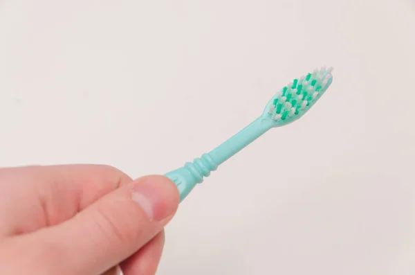 Escova de dentes na mão sobre fundo branco — Fotografia de Stock