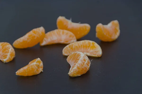 Share tangerine on a black background — Stock Photo, Image