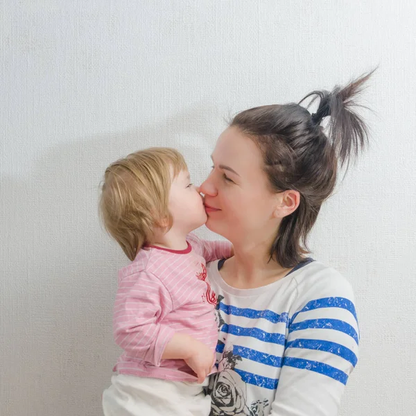 Elleri küçük kızımı üzerinde oturan Anne kisses — Stok fotoğraf